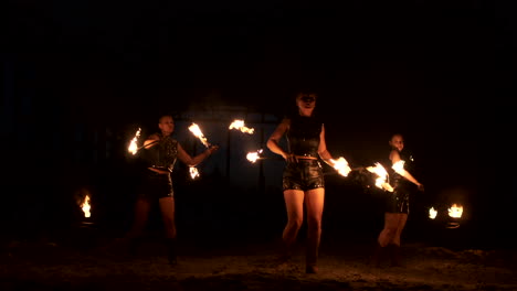 Professionelle-Feuershow-Im-Alten-Hangar-Der-Flugzeugshow-Professionelle-Zirkusartisten,-Drei-Frauen-In-Lederkombis-Und-Ein-Mann-Mit-Zwei-Flammenwerfern.